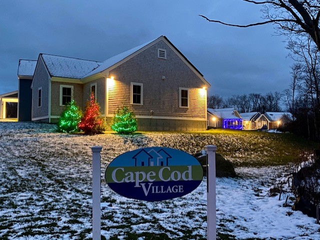 Cape Cod Village and lighted sign with snow in winter